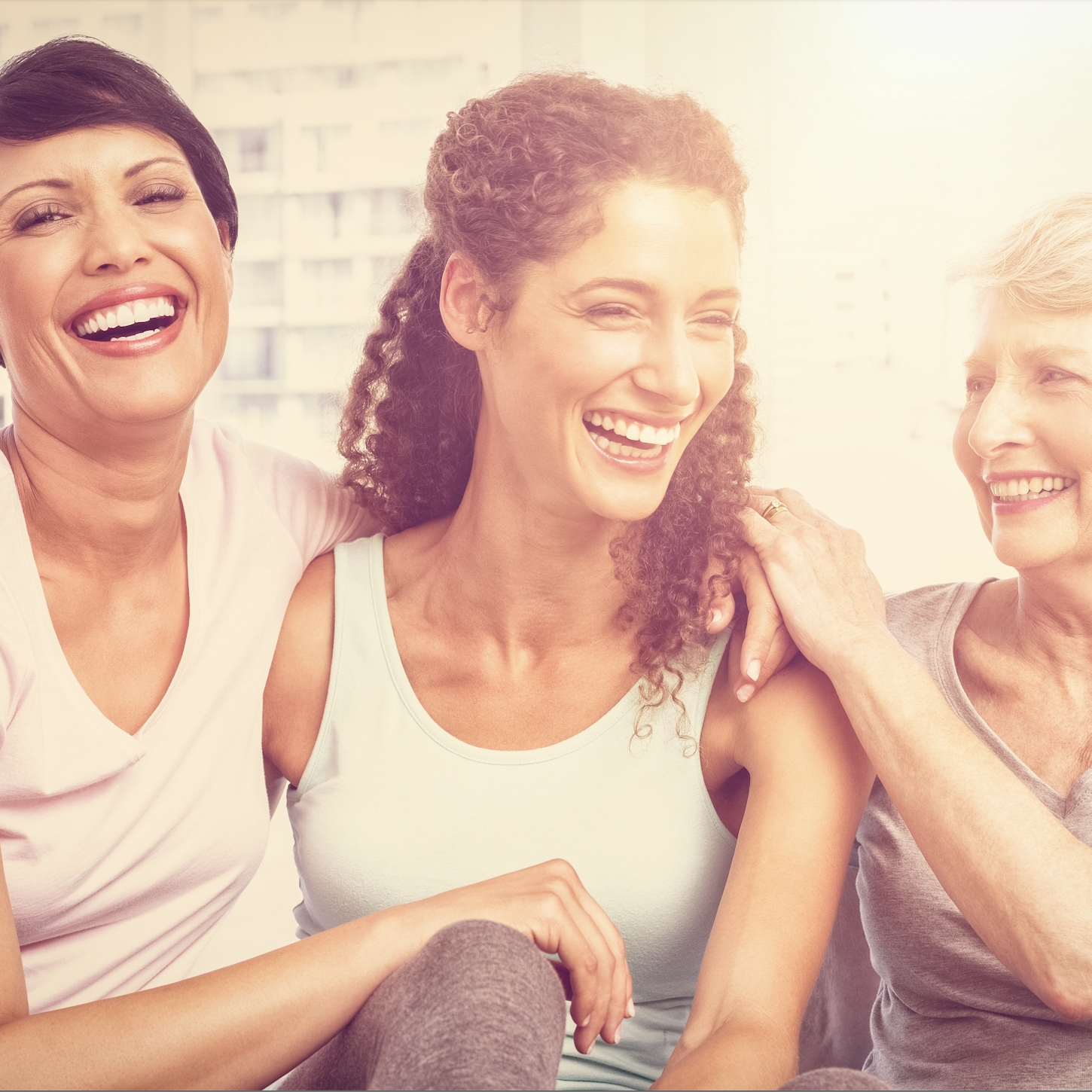 Drei Frauen stehen zusammen und lachen
