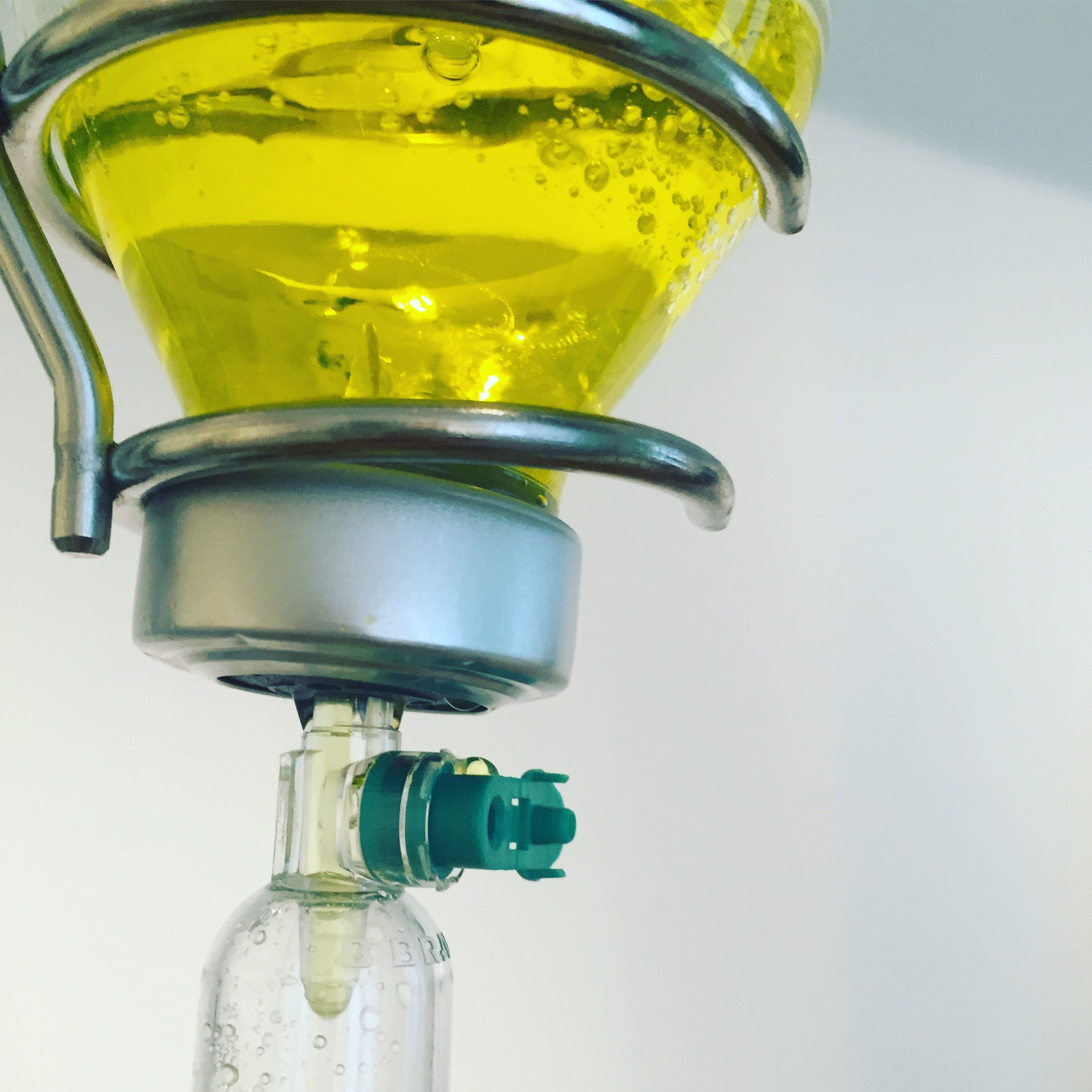Infusionsflasche mit gelber Lösung am Ständer